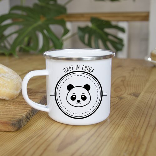 Mug en métal émaillé avec un panda, sur une table en bois